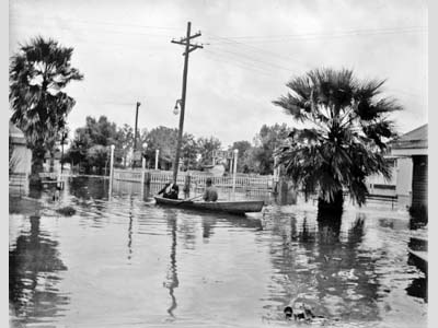 Two people in a row boat in a Flooded New Orleans amusement park.