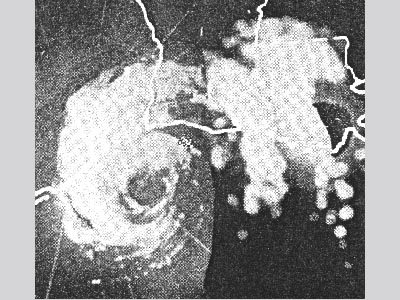 A grainy black and white radar image showing a circular spiral