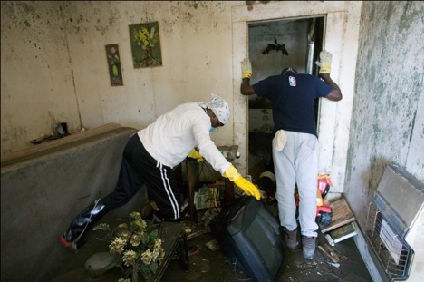 Residents of a New Orleans, LA, Lower 9th Ward home search for salvageable items in the aftermath of Hurricane Katrina (2005).