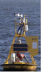 Two technicians with NOAA’s National Data Buoy Center repair a weather buoy off the North Carolina coast damaged by Hurricane Katrina